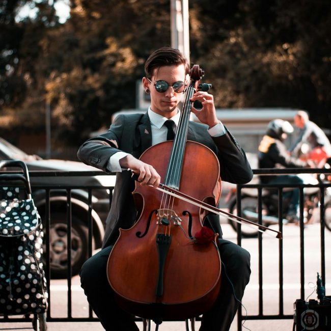 Mann spielt Cello auf der Strasse