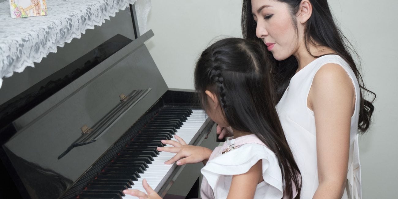 Schülerin mit Dozenting am Klavier