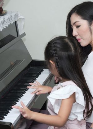 Schülerin mit Dozenting am Klavier